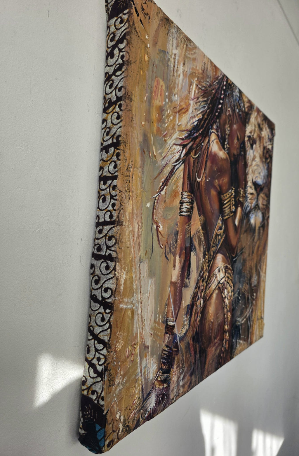 Side view of the 60 x 60 cm Queen Tsandzile canvas showing the black and white African fabric wrapped around the edges