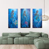 A 3-piece collection of mermaid art, underwater painting, textured art, African art work, inspired by  Swahlli history hung over a green sofa in a modern living room setting.