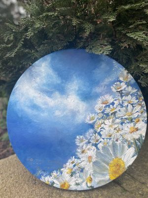 Round canvas painting of daisies against the blue sky
